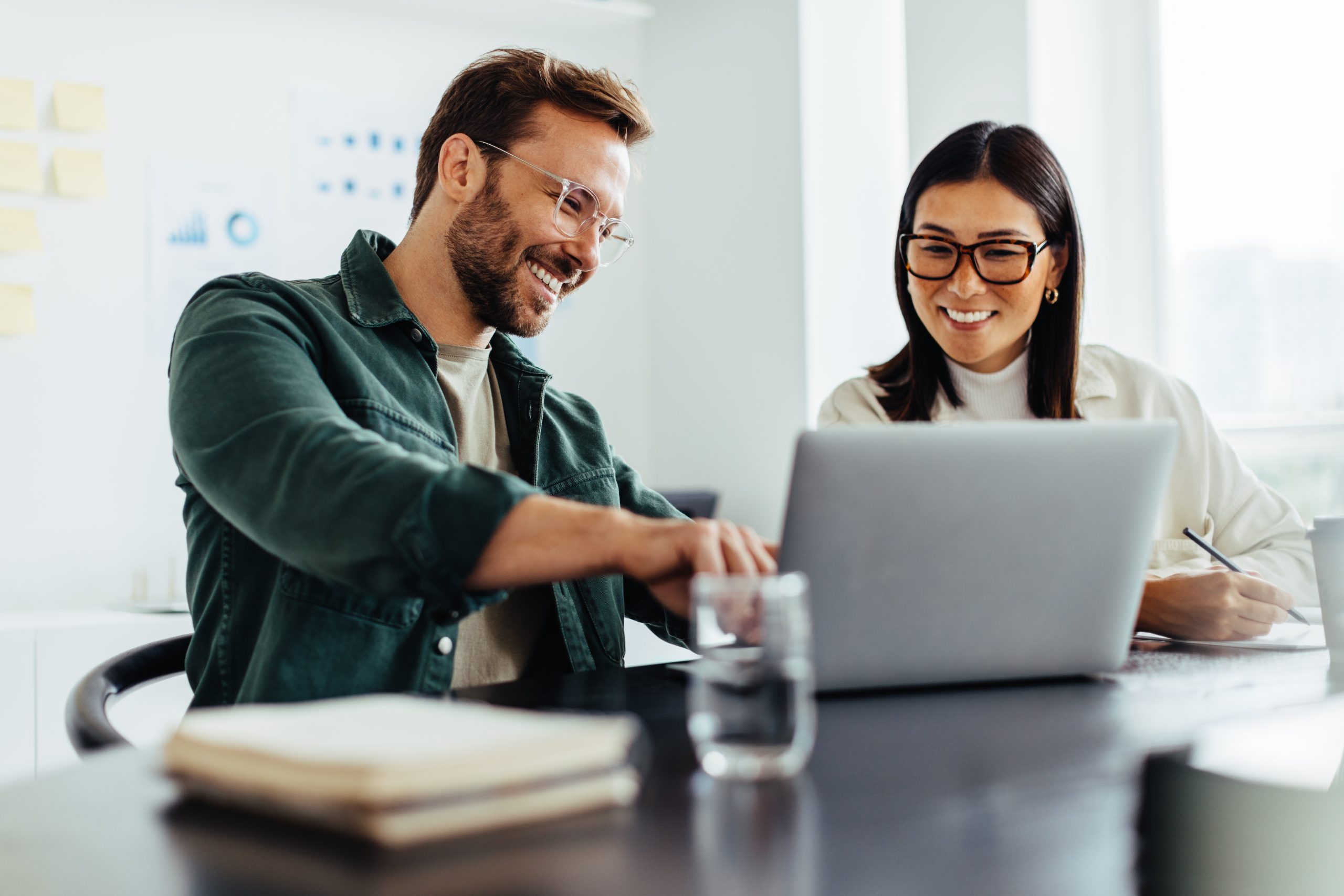 Person on laptop smiling after using tenant billing service to simplify their energy management