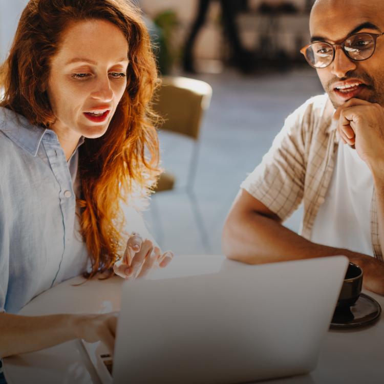 Image of two property managers, smiling and looking on a laptop, focusing on linking performance to compliance.